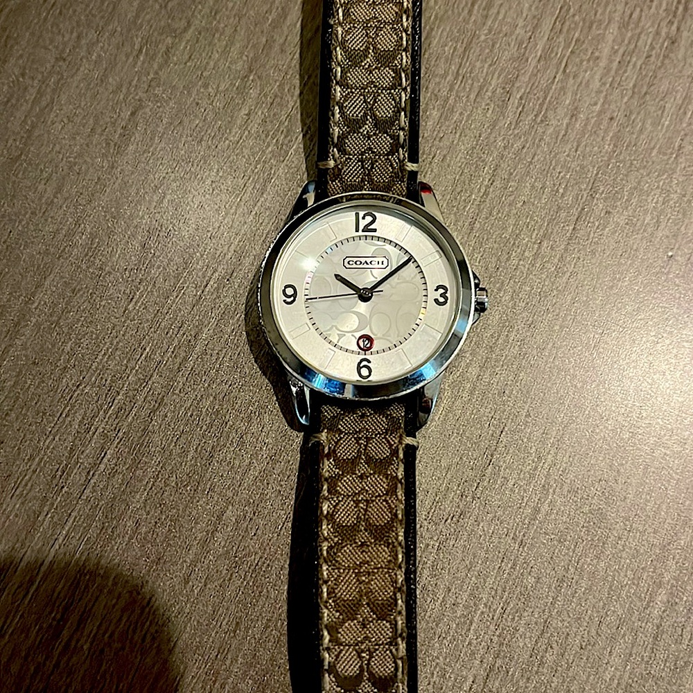Coach watch, stainless steel case with leather strap and coach logo design.